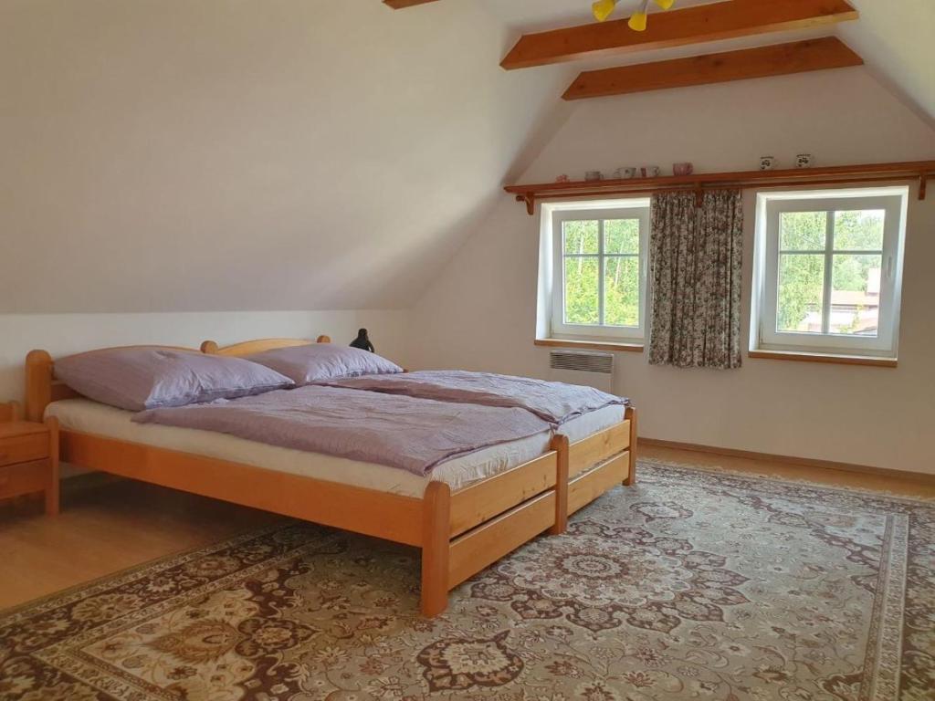 una camera da letto con un letto e due finestre di Chalupa Pěkný den a Rudník