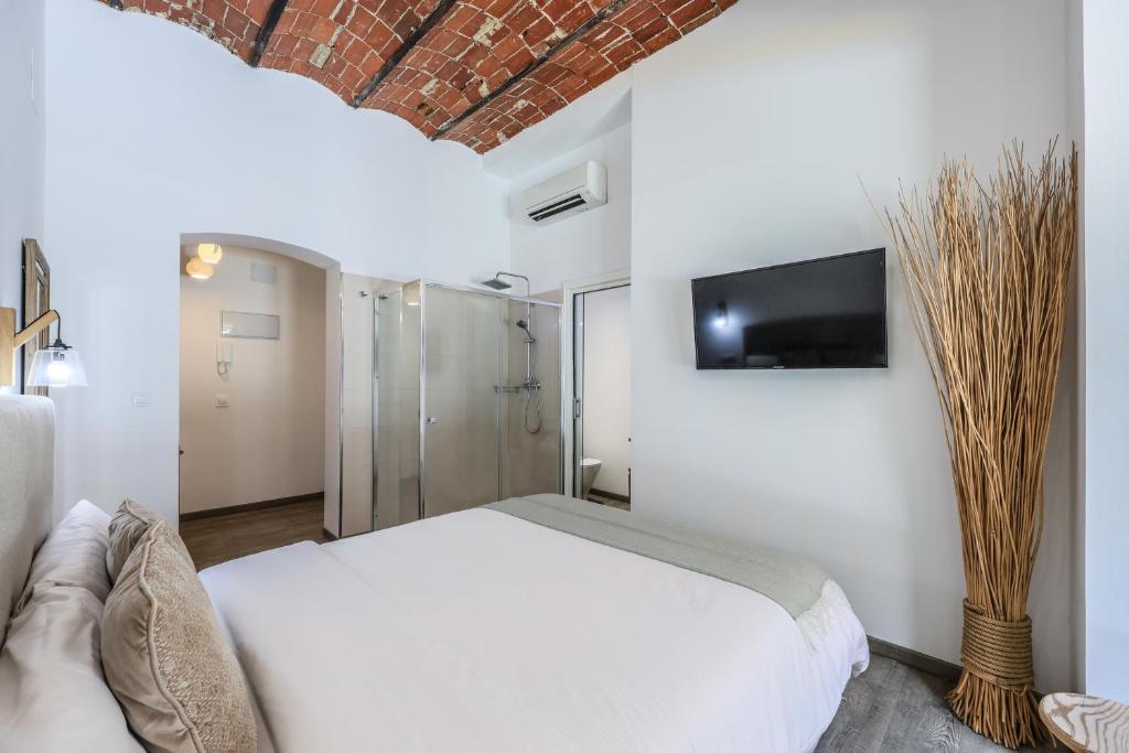 a bedroom with a white bed and a tv on a wall at Puerta del Sol Apartamento economico in Madrid