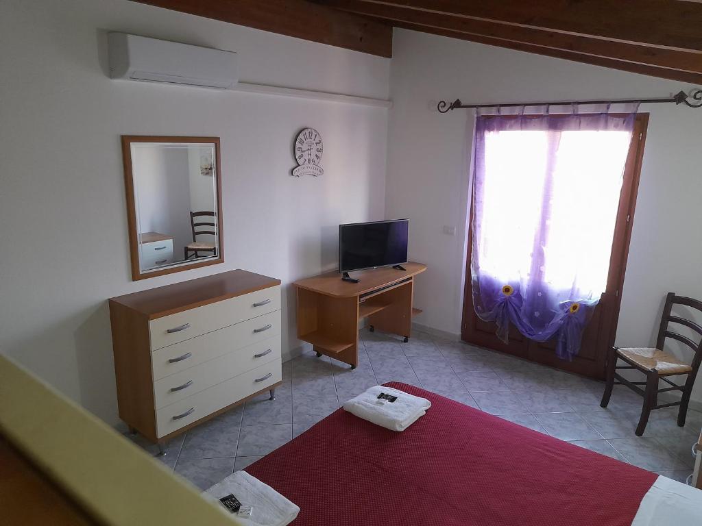 Samughèo的住宿－B&B da Marianna，一间卧室配有一张床和一张带镜子的书桌