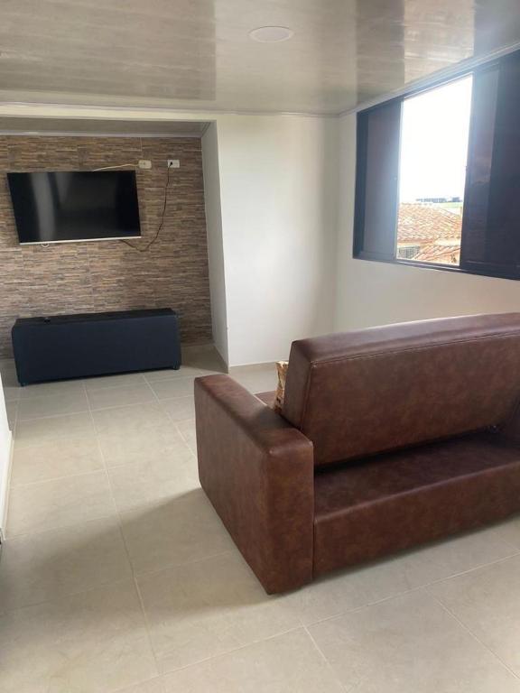 a living room with a brown couch and a flat screen tv at APARTA ESTUDIO NUEVO in Socorro