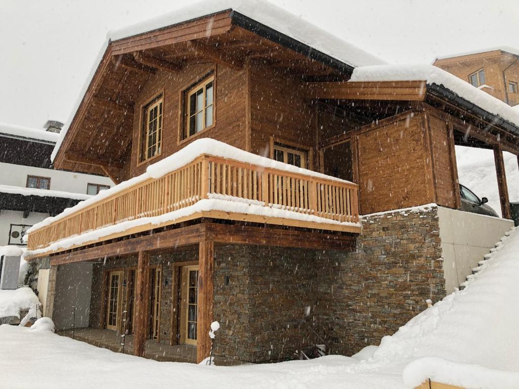 uma casa coberta de neve na frente em Soul Mountain Lodge em Mühlbach am Hochkönig