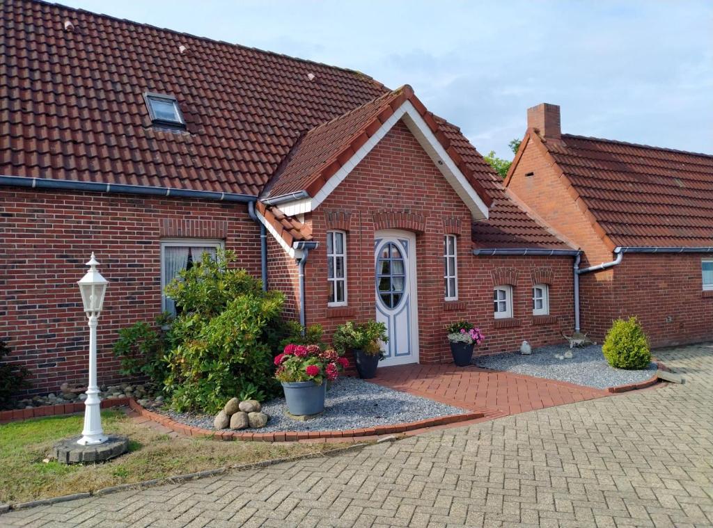 a red brick house with a white door at Dollart Huus in Jemgum