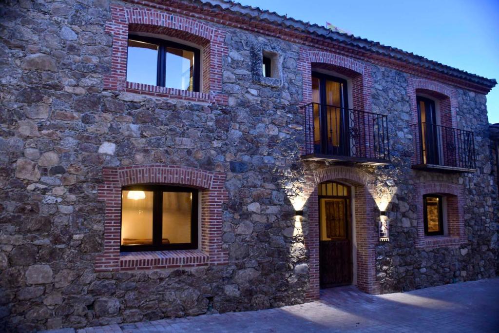 un edificio de ladrillo con ventanas y balcón en La Casa del Guarda - Turismo Sotosalbos, en Sotosalbos