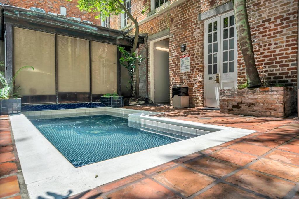 a swimming pool in front of a brick building at Hotel de L'eau Vive in New Orleans