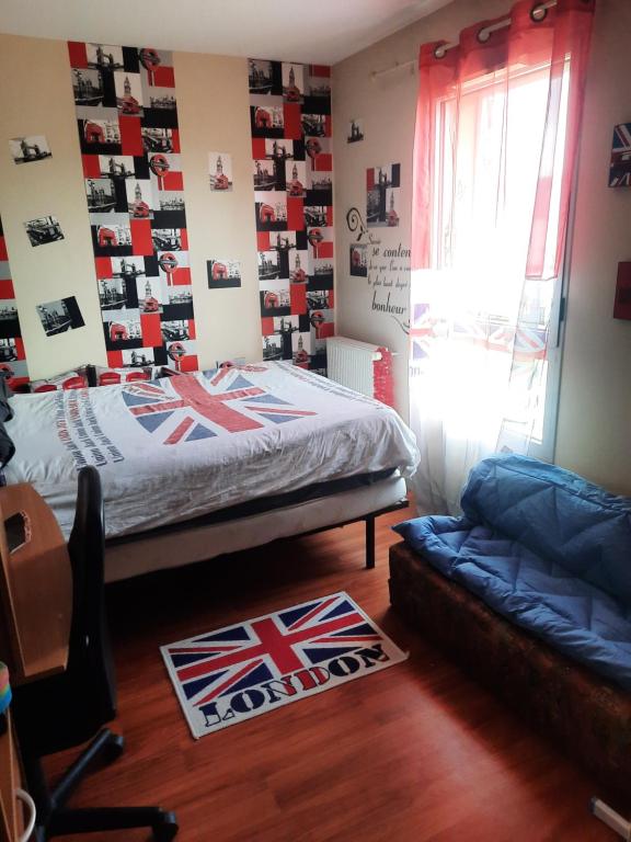 ein Schlafzimmer mit einem Bett und einem Sofa und Fotografien an der Wand in der Unterkunft Au Bonheur des enfants in Ibos