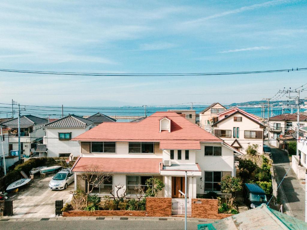 une maison avec un toit rouge dans une ville dans l'établissement シテコベハウス, à Yokosuka