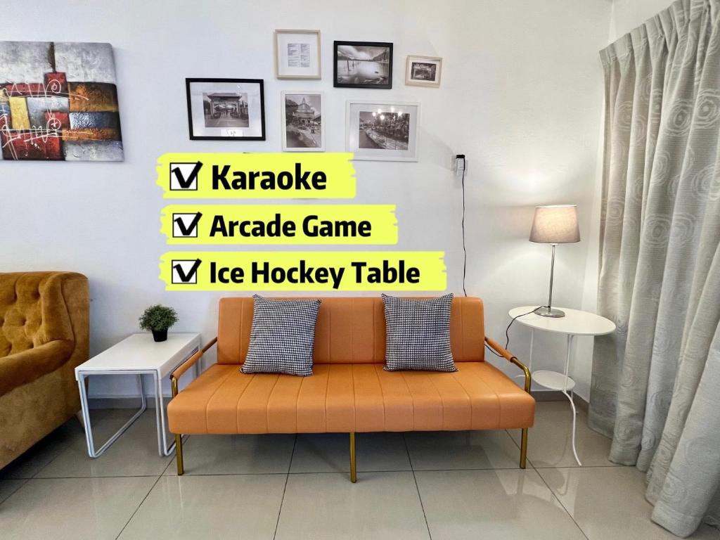 an orange couch in a living room with a sign at H&H 2 Karaoke, Ice Hockey Table, Game Console in Melaka