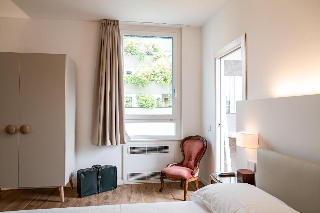 una camera da letto con un letto, una sedia e una finestra di Villa Tosati a Monza