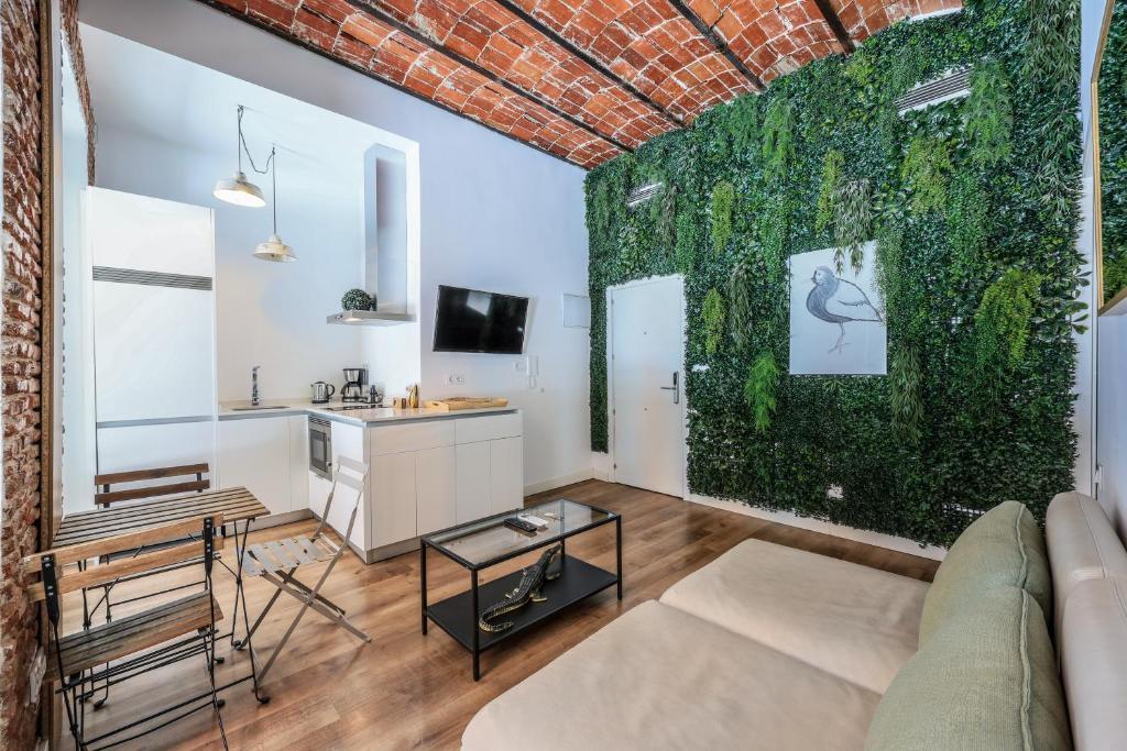 - un salon avec un mur vert dans l'établissement Apartamento centrico y comodo Preciados, à Madrid
