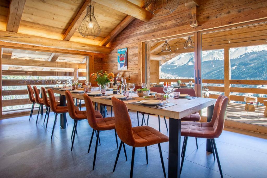 a dining room with a long table and chairs at Chalet Happyview - OVO Network in Le Grand-Bornand