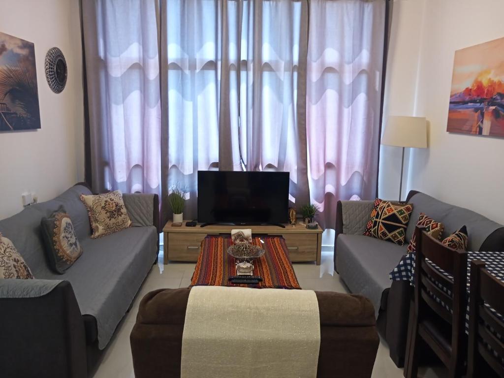a living room with two couches and a tv at Yafe Nof 35 in Ashqelon