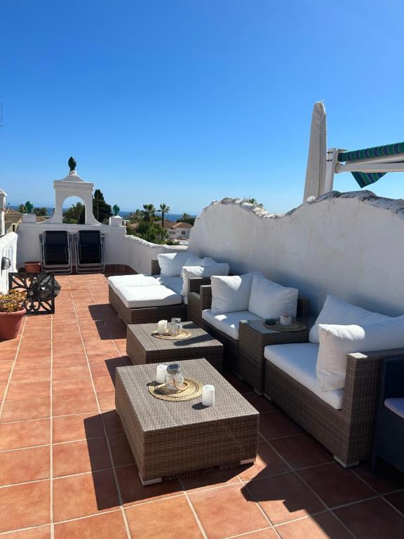 a patio with couches and tables on a roof at Mi Sitio in Sitio de Calahonda
