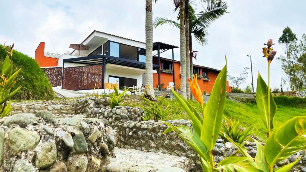 ein Haus auf einem Hügel mit Garten in der Unterkunft Aguas Claras Luxury Hospedaje in Filandia