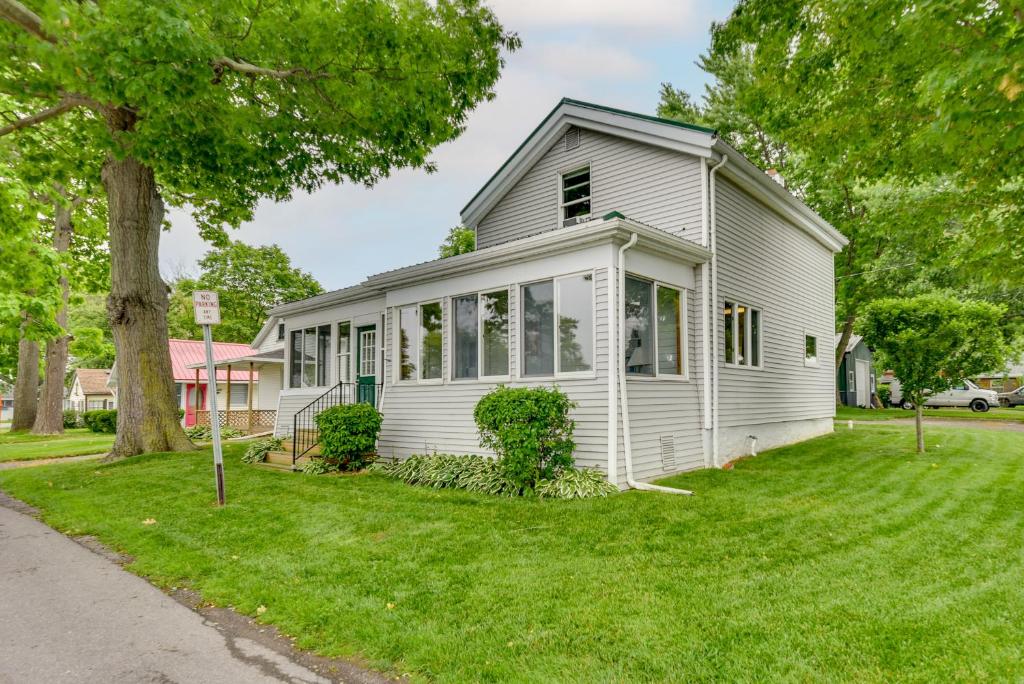 une maison blanche sur une pelouse avec un arbre dans l'établissement Point Breeze Vacation Rental, Walk to Lake Ontario, à Waterport