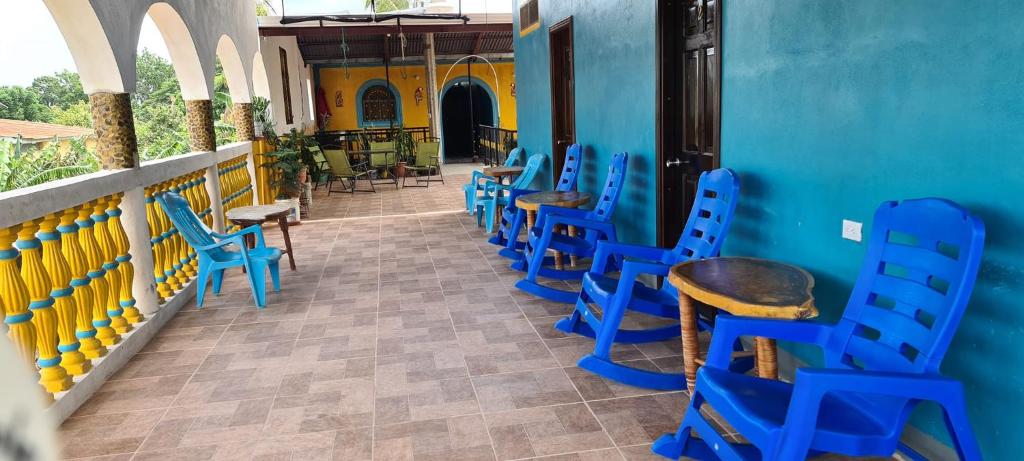 a row of blue chairs and tables on a balcony at Hostal Siero in Moyogalpa