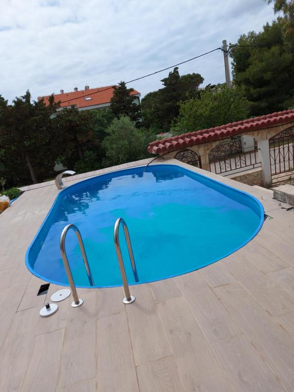 une grande piscine bleue sur une terrasse dans l'établissement Apartman 5-6, à Stara Novalja