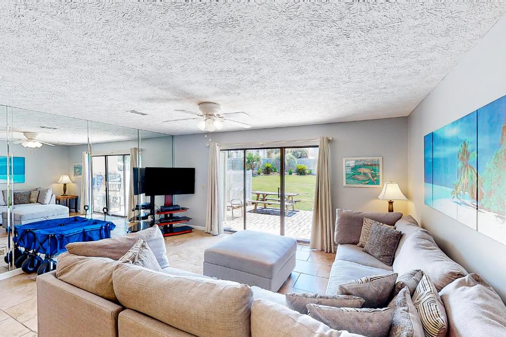a living room with a couch and a tv at Gulf Highlands - 238 Saint Katherine in Panama City Beach