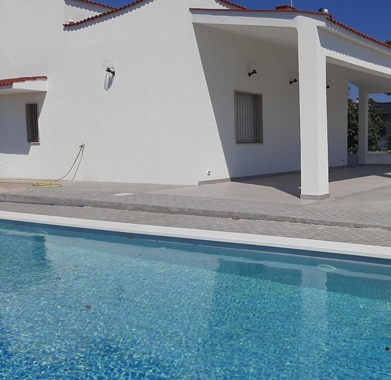 uma casa com piscina em frente a uma casa em VILLA LISA em Francavilla Fontana