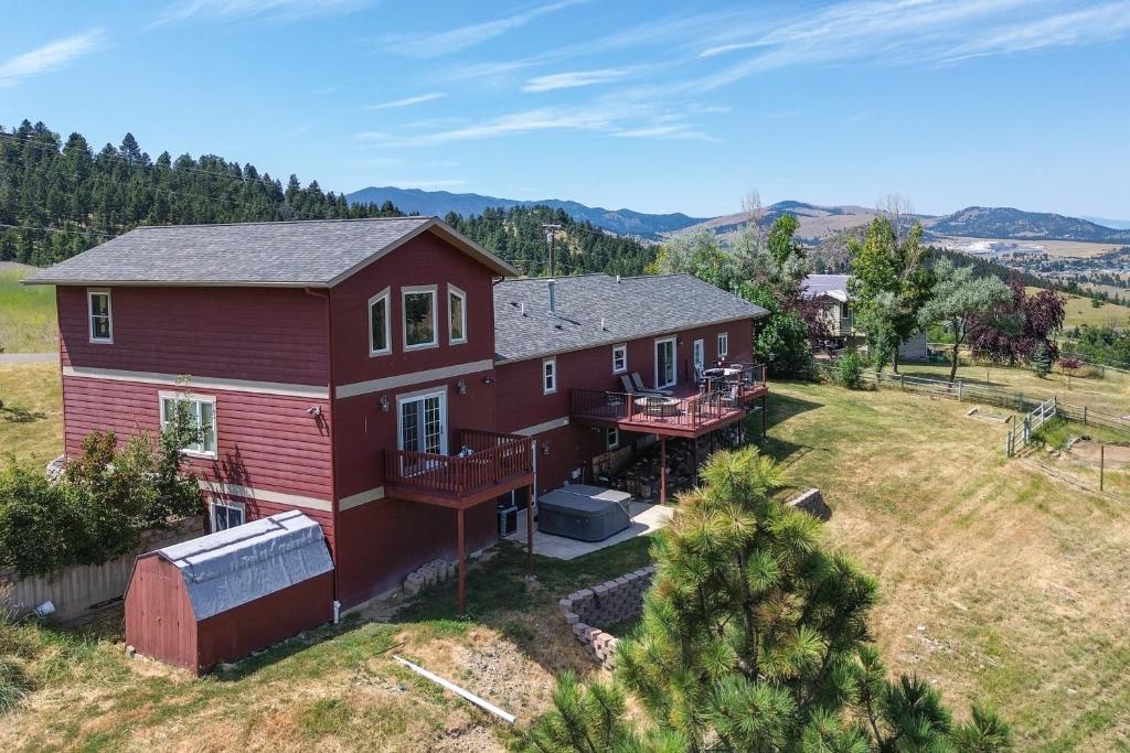 an aerial view of a red house with a yard at Mountain-View Rental with Hot Tub - 9 Mi to Helena! in Clancy