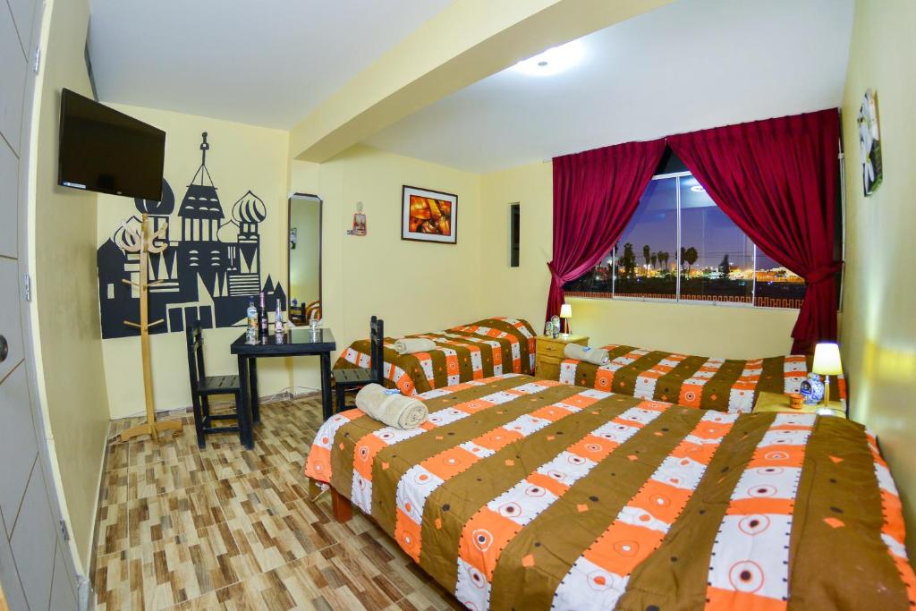 a bedroom with a bed and a desk and a television at Matryoshka in Ica