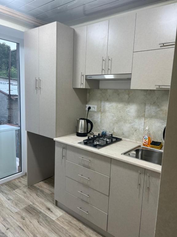 a kitchen with white cabinets and a sink at Sevan’s flat in Sevan