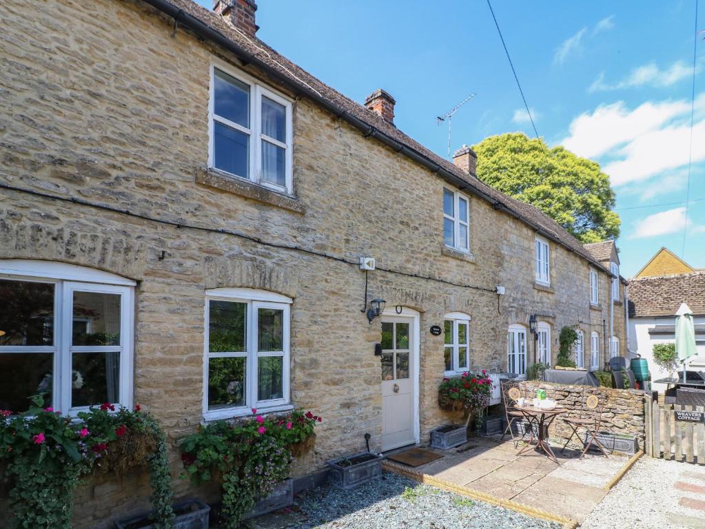 a large brick house with white doors and windows at Primrose Cottage Stow in Stow on the Wold