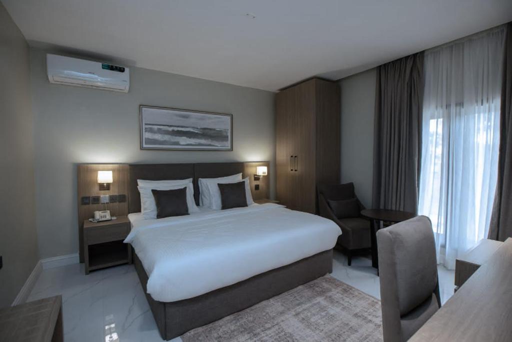 Habitación de hotel con cama grande y escritorio. en Knightsbridge Hotel & Suites, en Abuja