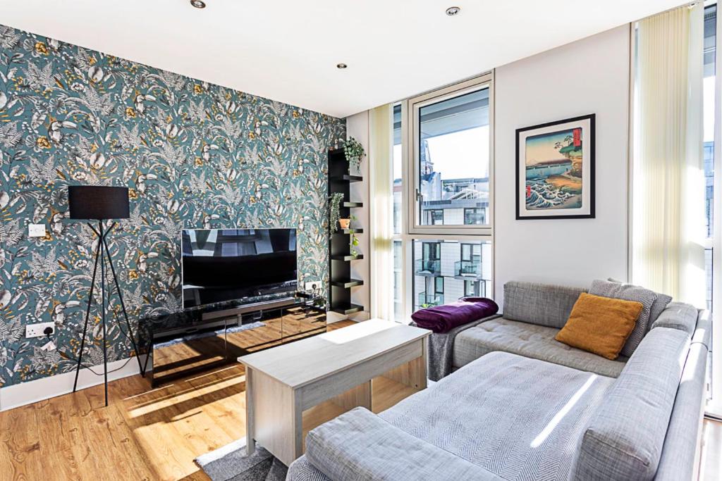 a living room with a couch and a tv at City-Close 1-Bed Apartment near Tower Hill in London