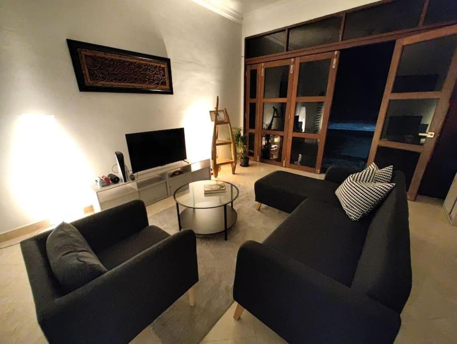 un soggiorno con 2 divani e una TV di IKHSHANA NATURE HILLSIDE HOME a Kuah