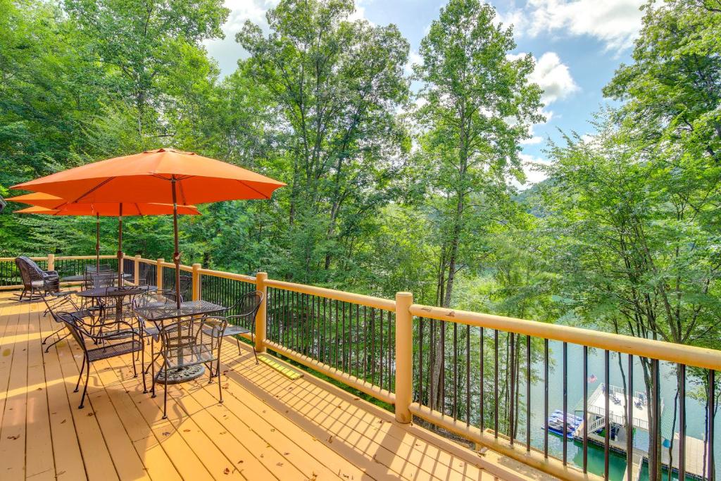 una terraza con mesas, sillas y sombrilla en Norris Lake Vacation Rental with Boat Slip, en New Tazewell