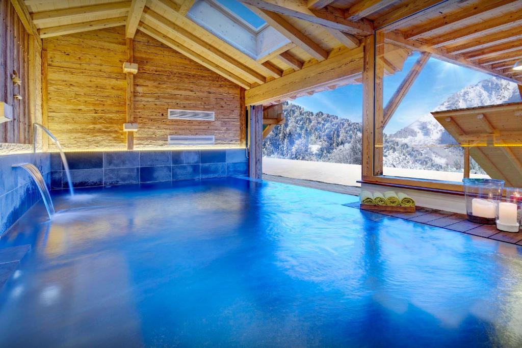 a swimming pool in a room with a mountain view at Chalet Ladroit - OVO Network in Les Clefs