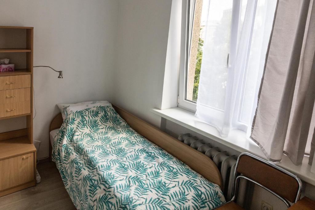 Cama en habitación con ventana en Mini Studio Vilnius Centre, en Vilna