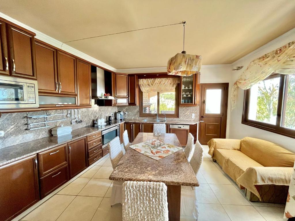 cocina y sala de estar con mesa y sofá en Two-floor luxury big house in Karpathos, en Apérion