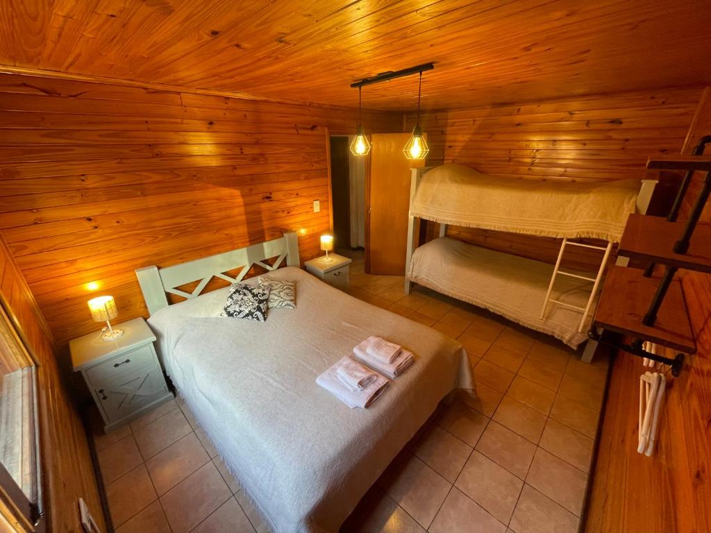 a bedroom with a bed in a wooden cabin at La Comarca Azul in El Calafate