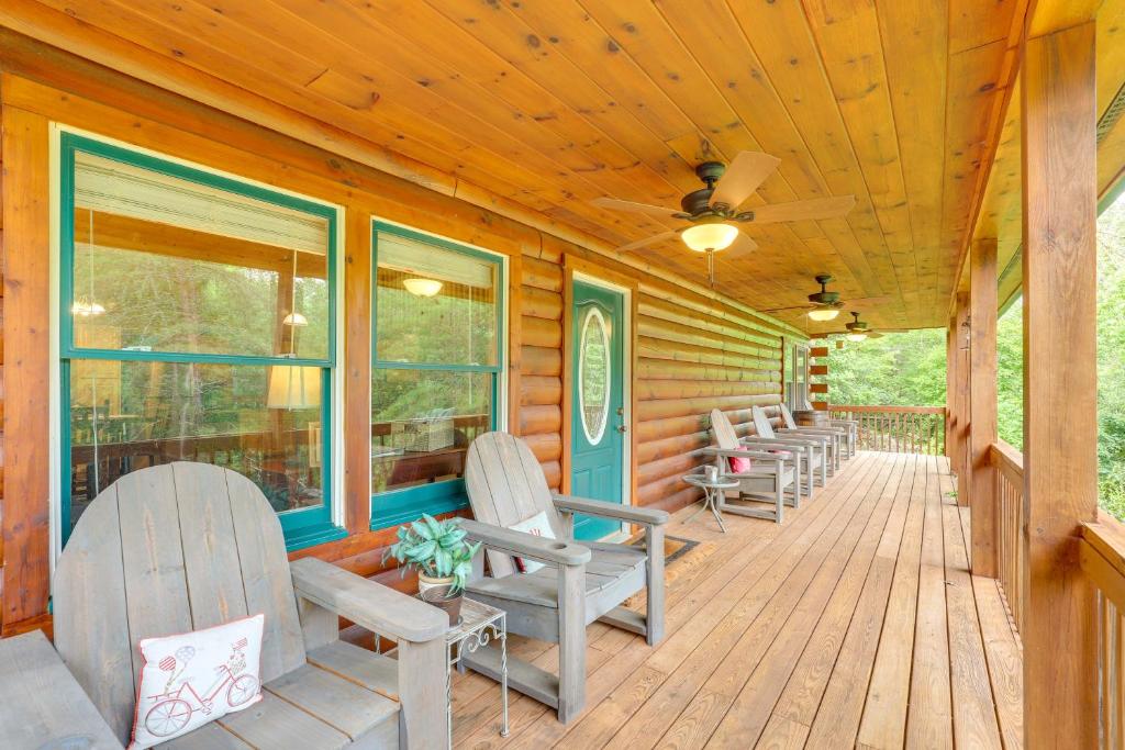 un portico di una cabina con sedie e finestre di Moonshine Manor Cabin with Fire Pit and Hot Tub! a Lake Lure