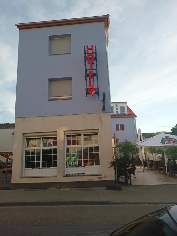 a white building with a sign on the side of it at Hotel Bruchsaler Herz in Bruchsal