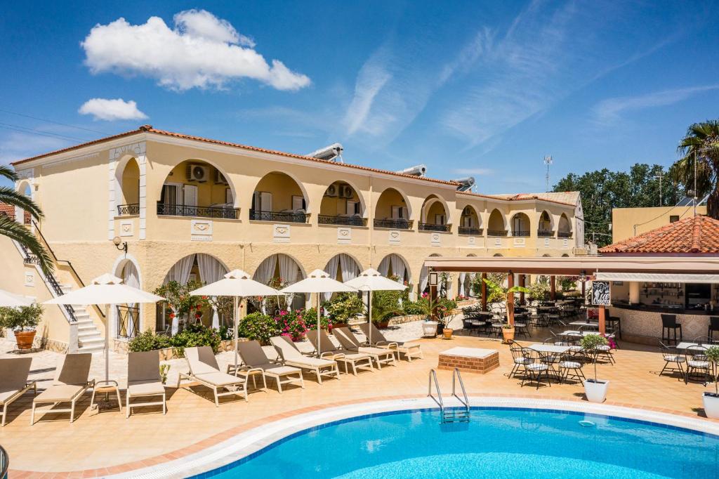 a hotel with a pool and chairs and umbrellas at Konstantina Apartments in Kavos