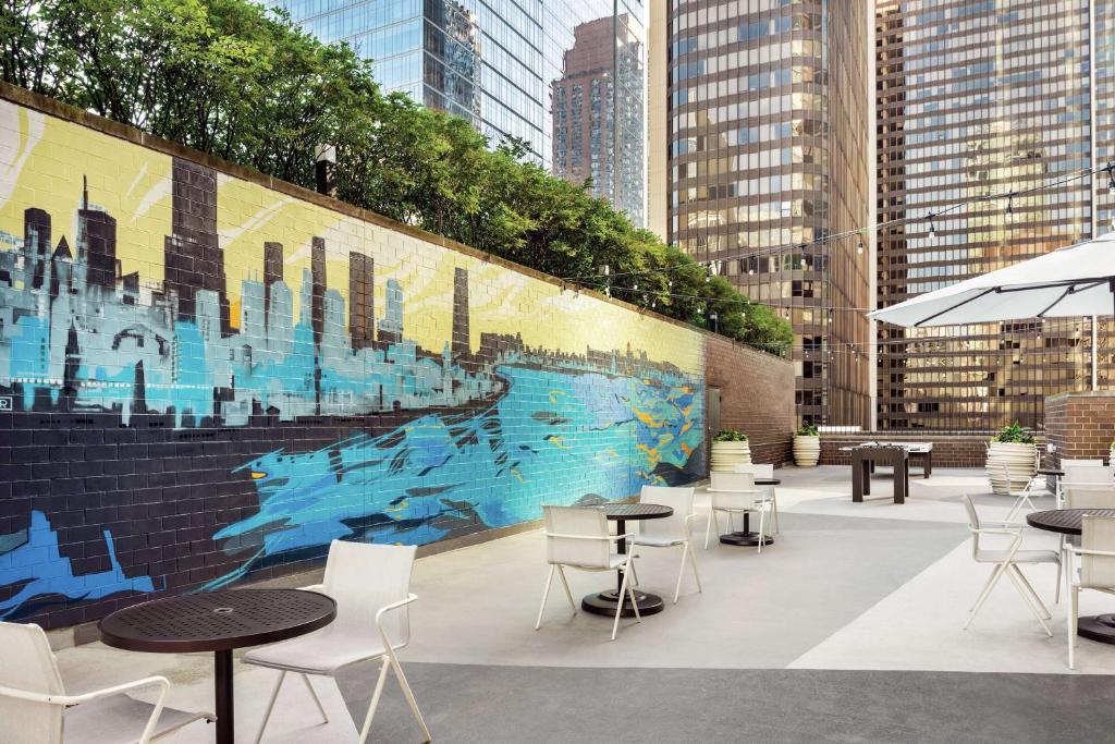 ein Wandgemälde an der Seite eines Gebäudes mit Tischen und Stühlen in der Unterkunft Hilton Grand Vacations Club Chicago Magnificent Mile in Chicago