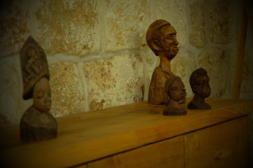 a group of statues sitting on top of a shelf at Pure Vida in ‘Akko