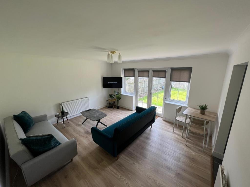 ein Wohnzimmer mit einem Sofa und einem Tisch in der Unterkunft Flat 1 Hobart Lodge in Hendon