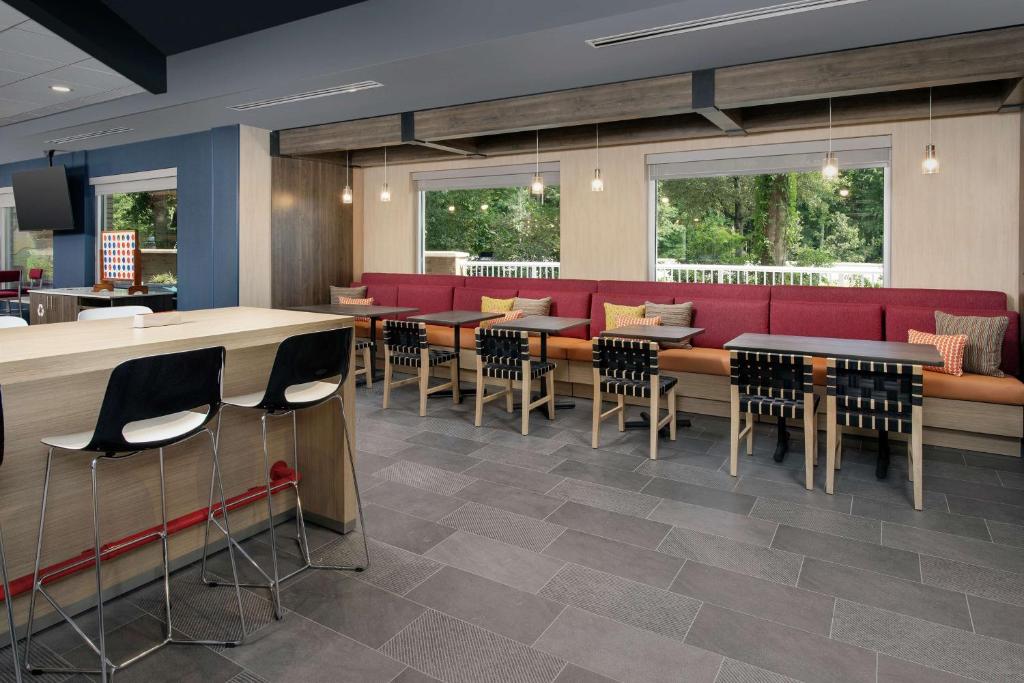 a restaurant with red couches and tables and chairs at Tru By Hilton Mt Pleasant Charleston in Charleston