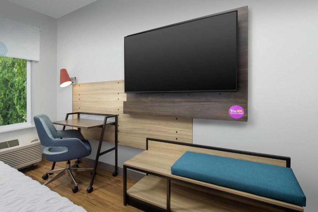 a bedroom with a desk and a tv on a wall at Tru By Hilton Mt Pleasant Charleston in Charleston