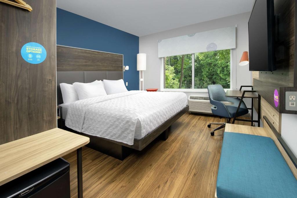 a hotel room with a bed and a desk and a chair at Tru By Hilton Mt Pleasant Charleston in Charleston