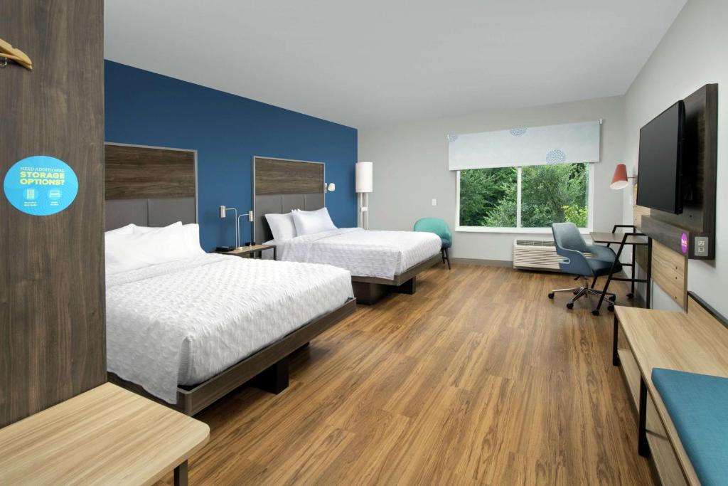 a hotel room with two beds and a flat screen tv at Tru By Hilton Mt Pleasant Charleston in Charleston