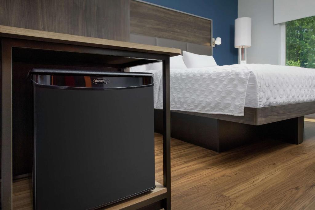 a bedroom with a bed and a black trash can at Tru By Hilton Mt Pleasant Charleston in Charleston