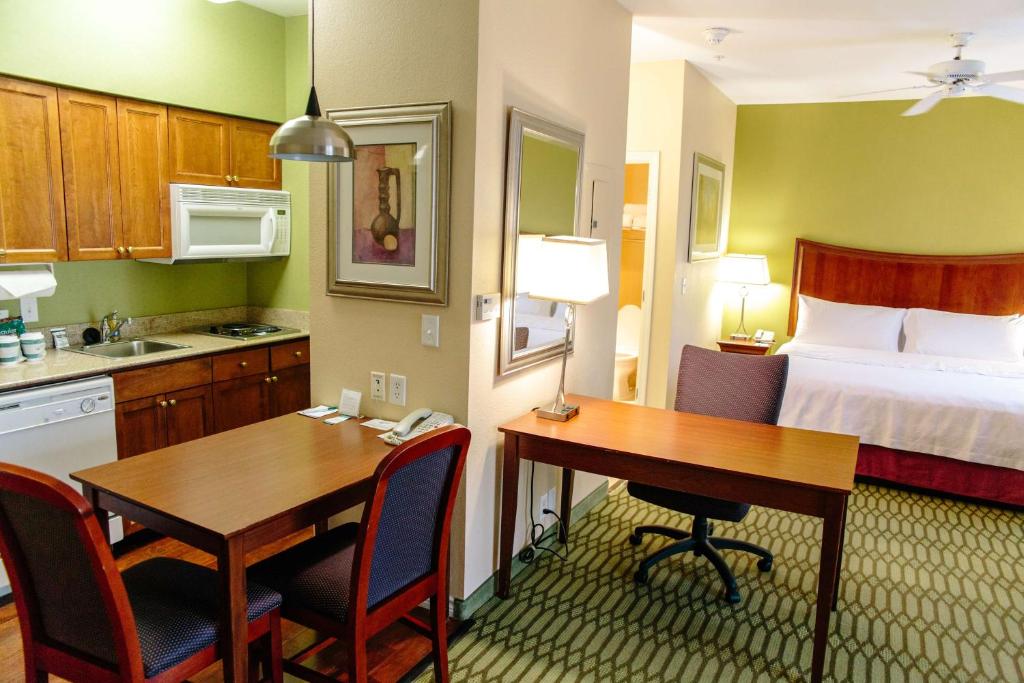 a hotel room with a kitchen and a desk and a bed at Homewood Suites by Hilton College Station in College Station