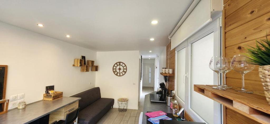 昂內維爾的住宿－Le coin Nature，客厅配有沙发和墙上的时钟