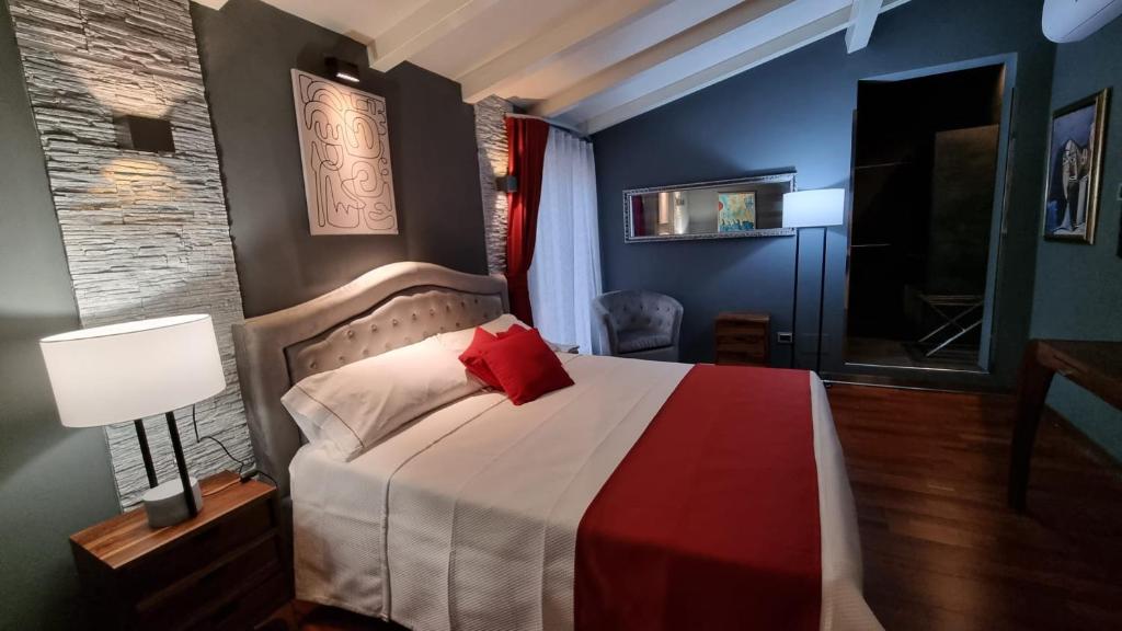 una camera con letto e cuscino rosso di Vi Ja Villa Janas Cagliari Resort a Cagliari