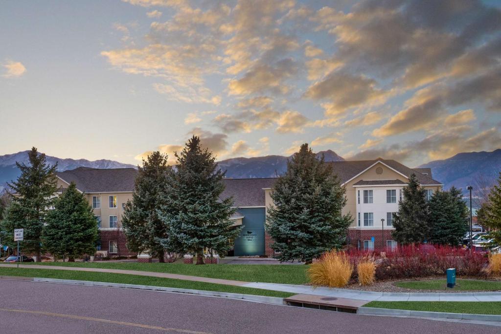 a building with trees and mountains in the background at Homewood Suites by Hilton Colorado Springs-North in Colorado Springs