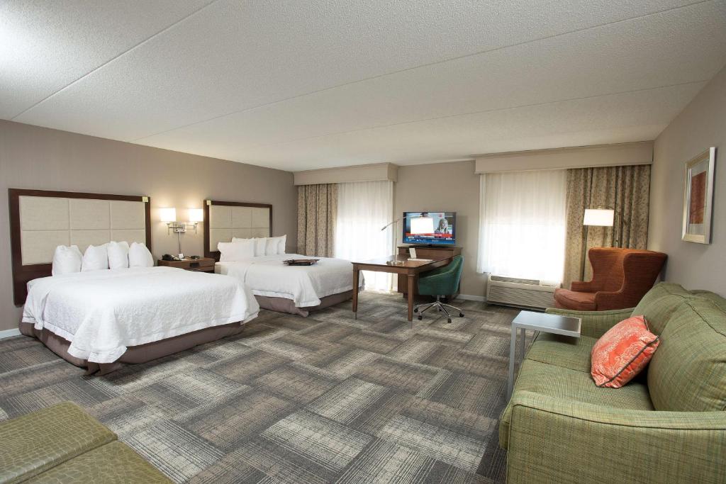 a hotel room with two beds and a couch at Hampton Inn & Suites Cincinnati-Union Centre in West Chester